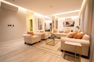 un ampio soggiorno con divani e tavolo di Riyadh Comfort Stay - Luxury الملقا Almalqa, 3 Bedrooms a Riyad