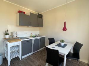 a kitchen with a desk and a table with chairs at Küstenbrise 2 in Graal-Müritz +3 photos