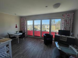 a living room with a large window and a table and chairs at Küstenbrise 2 in Graal-Müritz