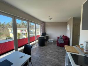 a living room with a red couch and a table at Küstenbrise 2 in Graal-Müritz