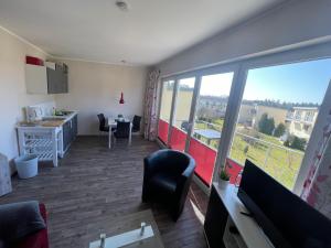 a room with a large window and a desk and chairs at Küstenbrise 2 in Graal-Müritz
