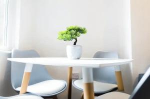 a white table with a plant on top of it at Bright 4BR Home, Perfect for Groups in Liverpool