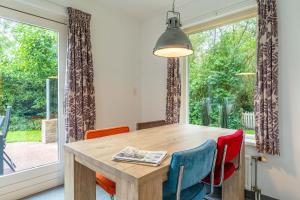 a dining room with a table and chairs and a window at Nieuwlanderweg 51 in De Waal