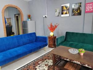 a living room with a blue couch and a table at Comfort Stay Kuala Perlis Wi-Fi Nexflix in Kuala Perlis