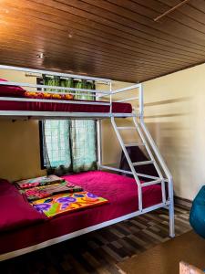 two bunk beds in a room with a red bed at Casspo bunk bed in Devikolam