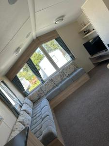 a living room with a couch and a large window at McCanns Caravan Marton Mere in Blackpool