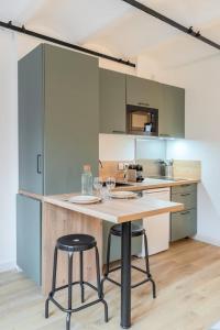 cocina con mesa y 2 taburetes en Old Lille - Lovely typical apartment !, en Lille