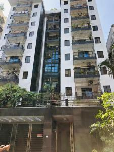 達卡的住宿－Amazing Apartment in Bashundhara，一座高大的白色建筑,阳台上有人