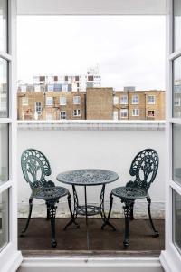 a table and two chairs on a balcony with a window at Veeve - Peaceful by Portobello in London