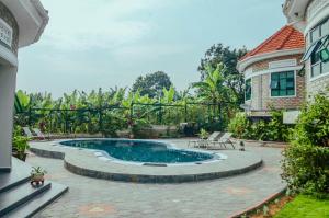 a backyard with a pool and a house at Ahaka Cottages in Mbarara