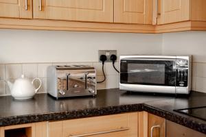 a kitchen counter with a microwave and a toaster oven at Cosy 2 bed home in Hoole perfect for your Chester break in Chester