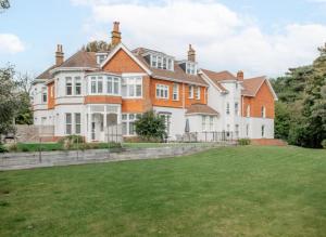 a large house with a green lawn in front of it at New Ground floor apartment, 4 mins walk to beach in Bournemouth