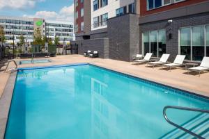 uma piscina com cadeiras e um edifício em Hyatt Place Boise-Meridian em Meridian