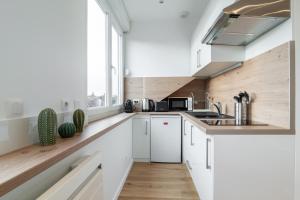 uma cozinha com armários brancos e uma janela em Lille Centre - Nice cozy and functional ap em Lille