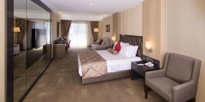 um quarto de hotel com uma cama e uma cadeira em Svalinn Hotel em Esmirna