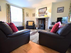 a living room with two leather couches and a fireplace at 2 Bed in Ripon HH039 in Bishop Monkton