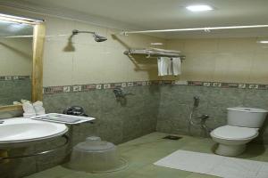 a bathroom with a toilet and a sink at HOTEL SKY PARK in Mattanūr