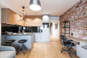 an open kitchen and living room with a brick wall at Otyńska Point Apartamenty Prestige in Wrocław