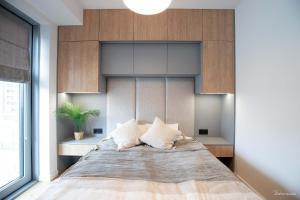 1 dormitorio con 1 cama grande con almohadas blancas en Otyńska Point Apartamenty Prestige, en Wroclaw