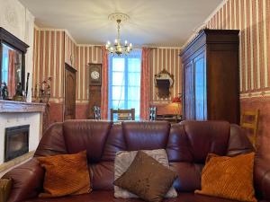 a living room with a brown leather couch at Chez Jeanne in Arnay-le-Duc