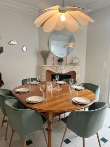 une table à manger avec des chaises et un lustre dans l'établissement L'idylle - Maison & Terrasse, à La Rochelle
