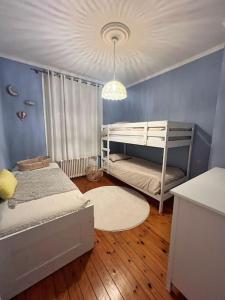 - une chambre avec 2 lits superposés et un mur bleu dans l'établissement L'idylle - Maison & Terrasse, à La Rochelle