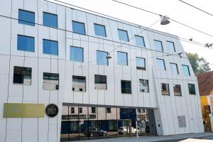 a white building with blue windows on a street at Best Western Hotel Spinnerei Linz in Linz