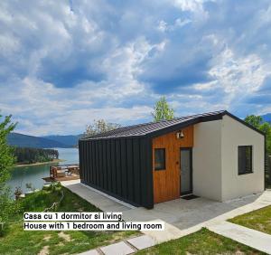 uma pequena casa com um exterior preto e branco em Moon Lake Bicaz em Buhalniţa