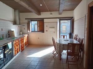 a kitchen with a table and chairs in a room at CASA DA RIBEIRA in Quiroga