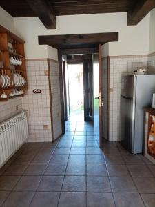 a kitchen with a refrigerator and a tile floor at CASA DA RIBEIRA in Quiroga