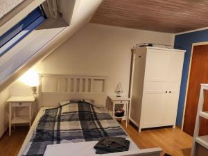 een slaapkamer op zolder met een bed en een trap bij Spatzenbergzimmer 2 in Obersulm