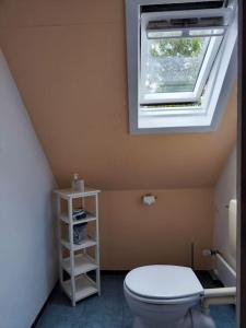 een badkamer met een wit toilet en een raam bij Spatzenbergzimmer 2 in Obersulm