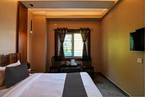 um quarto com uma cama, uma mesa e cadeiras em OYO Flagship Welcome Premium em Khandagiri