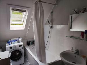 een badkamer met een wasmachine en een wastafel bij Spatzenbergzimmer 2 in Obersulm