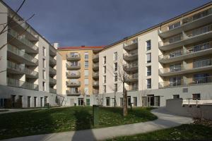 um edifício de apartamentos com um relvado em frente em DOMITYS LES SEQUANES em Chalon-sur-Saône