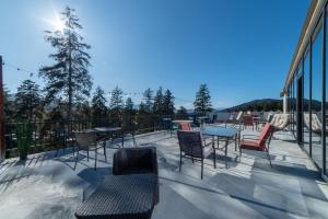 d'une terrasse avec des tables et des chaises sur un balcon. dans l'établissement Grand Noel Bakuriani, à Bakuriani