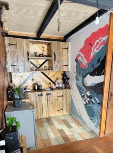 a kitchen with wooden cabinets and a large painting on the wall at Gudauri Glamping in Gudauri