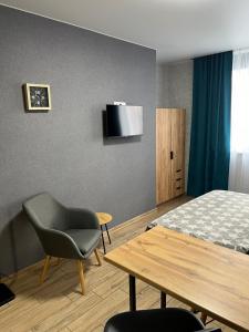 een slaapkamer met een bed, een tafel en een stoel bij 014-2 Новые Смарт-апартаменты ЖК Олимпия in Kiev