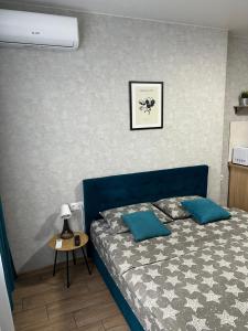 1 dormitorio con cama azul y almohadas azules en 014-2 Новые Смарт-апартаменты ЖК Олимпия, en Kiev