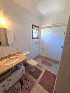 uma casa de banho com um chuveiro, um WC e um lavatório. em Pacotes Carnaval - Sobrado perto MAR em Capão da Canoa