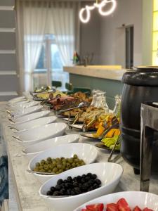 una fila de tazones blancos de fruta sobre una mesa en Mona Hotel and Cottages, en Sütǝmurdov