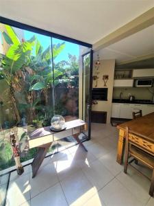 een woonkamer met een groot raam en een tafel bij Pacotes Carnaval - Sobrado perto MAR in Capão da Canoa