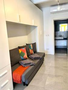 ein Wohnzimmer mit einem Sofa in einem Zimmer in der Unterkunft Cosy seafront haven in Kalkara