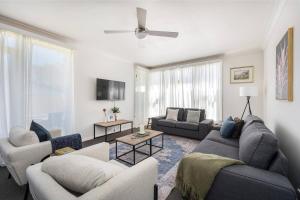 a living room with two couches and a tv at Bancroft House on Scenic Mudgee Golf Course in Mudgee