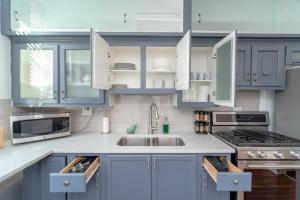 a kitchen with blue cabinets and a sink at Historical 5 Bedroom Villa that sleeps 12 guests with Patio, Fireplace, Grill and FREE parking in Chicago