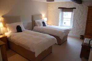 1 dormitorio con 2 camas y ventana en Simple Luxury in Brecon Beacons Village House, en Llandovery