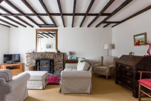 sala de estar con chimenea, sofá y sillas en Simple Luxury in Brecon Beacons Village House, en Llandovery