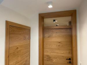 a wooden door in a room with a mirror at Lake & Town Apartments Klagenfurt in Klagenfurt