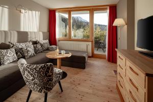 - un salon avec un canapé et une table dans l'établissement Sporthotel Obereggen, à Obereggen