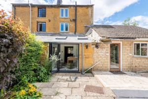 an extension to a brick house with a patio at Idilic Cottage The Sheaf in Blockley